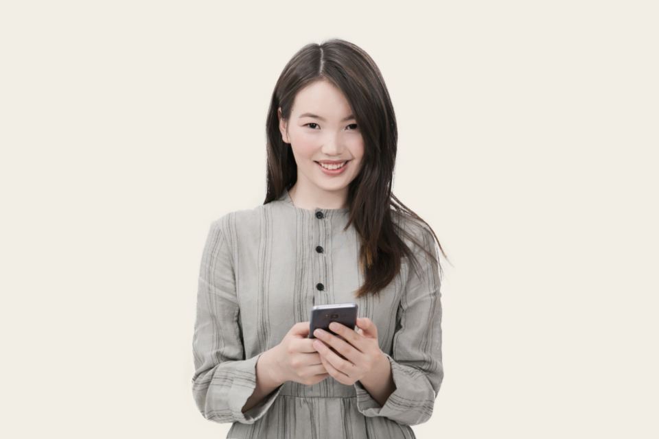 A parent smiling while using their phone