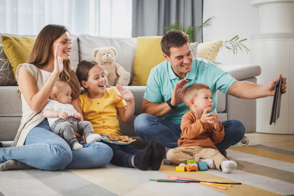 A family smiling and laughing together while looking at a tablet